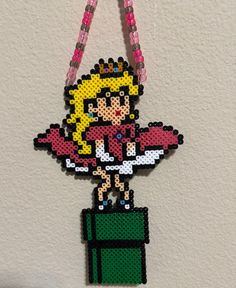 Marilyn Monroe Inspired princess peach perler. Please message me if you would just like the perler or attached to a beaded necklace **All items are hand made to order by me, please keep in mind  what you receive may vary a little from the photos, beads may melt differently than shown in the pictures. Princess Peach Perler, Peach Perler, Princess Peach Crown, Hama Mario, Marvel Room, Pixel Grid, Kandi Necklace, Grid Art, Peach Mario