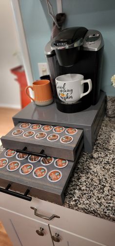 a coffee maker sitting on top of a counter next to cupcakes