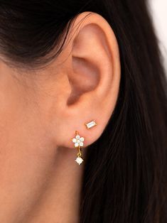 "These tiny flower hoop earrings feature a sparkly CZ flower and a dangling cz charm. A dainty and elegant pair that looks gorgeous layered with other earrings, but is just as beautiful worn alone for a more minimal look. Can also be worn on a cartilage/helix piercing. ∙ Sold individually (1 earring) or as a pair (2 earrings) * D E T A I L S * ∙ Material: .925 Sterling Silver or 18K Gold Plated over .925 Sterling Silver ∙ Inner diameter: 8mm // Flower: 6mm ∙ Hypoallergenic & nickel-free * P Cartilage Helix Piercing, Baguette Studs, Tiny Gold Studs, Baguette Earring, Flower Hoop Earrings, Dainty Hoop Earrings, 2 Earrings, Dainty Studs, Tiny Studs