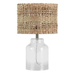 a glass table lamp with a woven shade