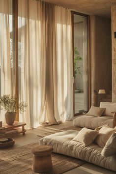 a living room filled with furniture and large windows