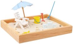 a toy sandbox with an umbrella and chairs