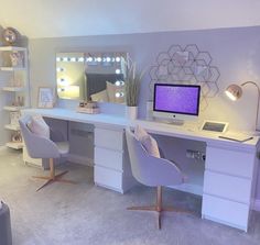 a white desk topped with a computer monitor next to a mirror and chair in a room