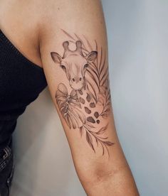 a giraffe tattoo on the left arm