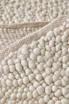 a close up view of the texture of a white and beige blanket with circles on it