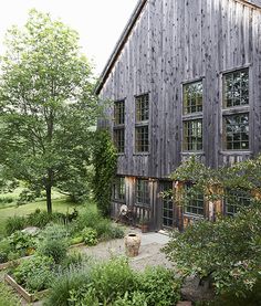 a large wooden building sitting next to a lush green forest filled with lots of trees