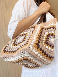 Crochet Granny Square Bag, Crochet Tote Bag for Women, Retro Bag, Hippie Bag, Summer Bag, Bohemian Style Beige Tote Bag, Women's Gift Bag, Crochet Beige Handmade Tote Bag 📌 The Colorful Crochet Granny Square Bag consist of 5 crochet motif pieces. The main color of the crochet bag is beige and it is fully lined inside. The bag can close also with a magnet. And it has a pocket 🌸🎁 Whether for yourself or as a thoughtful gift, our crochet tote bag is a stylish and practical choice for all occasions. 🌸🎁 Order Now to add a touch of handmade elegance to your everyday life or surprise someone special with a gift that combines beauty and functionality. >> BAG SIZE << Bag length: 24 cm Bag width: 39 cm Strap length: 26 cm Strap color: Dark Brown >> MATERIAL << %49 Cotton %50 Acrylic >> CARE INS Brown Crochet Tote Bag With Granny Square, Beige Granny Square Bag For Daily Use, Beige Granny Square Shoulder Bag For Everyday, Beige Granny Square Shoulder Bag, Brown Granny Square Crochet Tote Bag, Everyday Beige Shoulder Bag With Granny Square, Cream Square Crochet Bag For Everyday, Beige Bohemian Crochet Bag With Handles, Bohemian Beige Crochet Bag With Handles