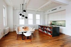 an open kitchen and dining room with hardwood floors, white walls, and wooden flooring