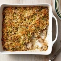 a casserole dish with meat and vegetables in it next to a bowl of soup