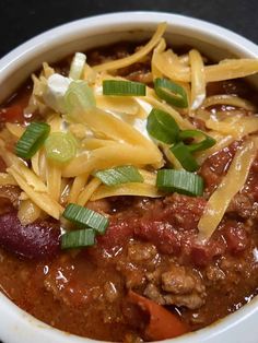 a white bowl filled with chili and cheese