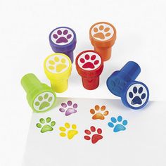 dog paw stampers are shown on top of a piece of paper with colored ink