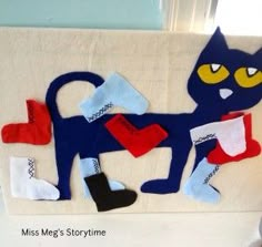 a blue cat with yellow eyes and red socks on it's feet is sitting next to a white towel