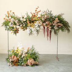 an arrangement of flowers and greenery on display