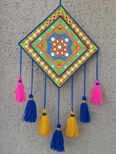 a colorful wall hanging with tassels on it