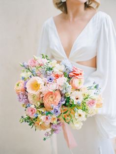 a woman holding a bouquet of flowers in her hand