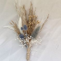 dried flowers are arranged on a white surface