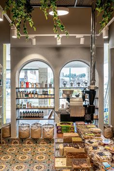 the inside of a store with lots of items on display and plants hanging from the ceiling