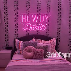 there is a bed with pink sheets and pillows in front of a neon sign that reads, hodgy dawn