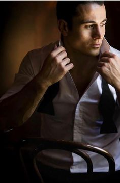 a man sitting at a table tying his tie