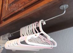 two white hangers are hanging from the ceiling in front of a wooden cabinet with drawers