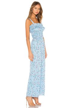 A Floral Fantasy: Embrace the beauty of spring with the Tularosa Ellie Jumpsuit in Carolina Blue Floral, a captivating piece adorned with a delicate wildflower print that gently speckles a rich aqua hue.Smocked Bodice for a Flattering Fit: The smocked bodice of this jumpsuit provides a comfortable and flattering fit, while the ruffle trim adds a touch of playful elegance.Versatile and Effortlessly Stylish: Whether you're strolling through a blooming garden or attending a special occasion, this v Blue Floral Jumpsuit, Embroidered Top Designs, Romantic Dress, Blue Floral Print, Floral Jumpsuit, Trim Detail, Carolina Blue, Ruffle Trim, Spring Flowers