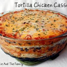 a casserole dish with cheese and vegetables in it on a white tablecloth