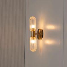 two lights that are on the side of a wall next to a door in a room