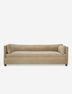 a beige couch with two pillows on the back and one arm up against it's head