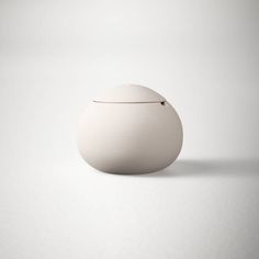 an egg shaped container sitting on top of a white surface