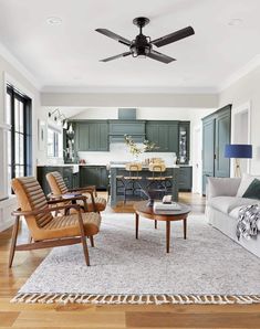 a living room filled with furniture and a ceiling fan in the middle of an open floor plan