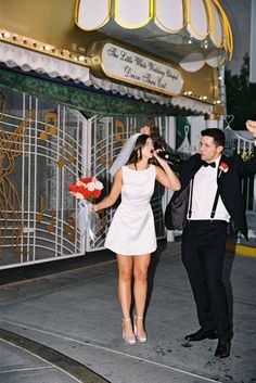 a bride and groom are walking down the street