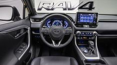 the interior of a car with dashboard, steering wheel and display screen showing rav 4