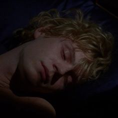 a young man sleeping in the dark with his eyes closed