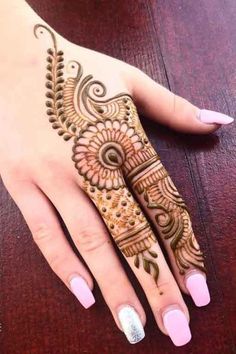 a woman's hand with henna tattoos on it