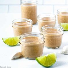 several small jars filled with different types of food and limes next to each other