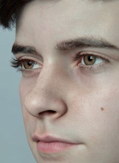 a close up of a young man with freckles on his face