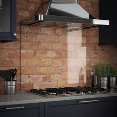 a stove top oven sitting inside of a kitchen next to a wall covered in bricks