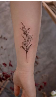 a woman's arm with a flower tattoo on it