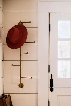 a red hat is hanging on the wall next to a white door