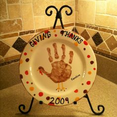 a plate with a handprint on it that says giving thanks