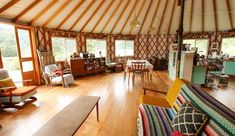 a living room filled with lots of furniture next to a wooden floor covered in windows