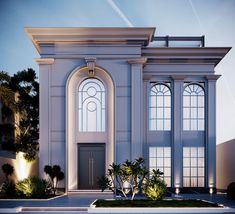 a large white building with arched windows and plants in the front yard at night time