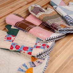 several pieces of quilt sitting on top of a wooden floor next to eachother