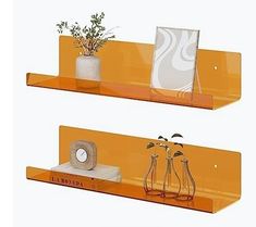 two orange shelves with vases and plants on them