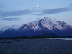 the mountains are covered in snow at dusk