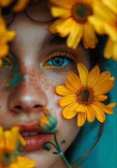 a woman with blue eyes and freckles on her face is surrounded by yellow flowers