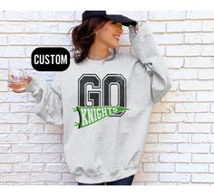 This personalized team name sweatshirt is the perfect gift for any sports fan.  ✨Shipping & Processing - Please allow 2-5 business days for your item to be processed and printed. Processing times may be longer during busy holiday periods. - Your order ships from the US. Allow 2-7 business days shipping. Unfortunately, I am unable to guarantee USPS shipping times. ✨Returns✨ If there is a defect with your order, please reach out to us within 15 days of receiving the item. We will be happy to resol Team Spirit Sweatshirt With Team Name For Baseball Season, Baseball Season Sweatshirt With Team Name For Fan Gear, Baseball Season Sweatshirt For Sports Events With School Spirit, Varsity Sweatshirt With Team Name For Baseball Season, Customizable Fall Sweatshirt With School Spirit, School Spirit Sweatshirt For Sports Events And Baseball Season, Customizable Fan Gear Sweatshirt, Casual Custom Print Sweatshirt For College, Customizable Team Spirit Sweatshirt For Sports Events