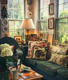 a living room filled with lots of furniture and windows covered in pictures on the walls