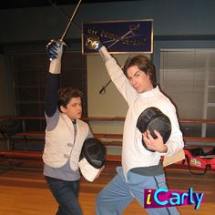 two young men wearing boxing gloves and holding their hands in the air