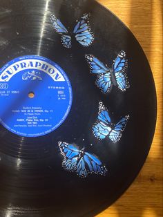 a black record with blue butterflies on it